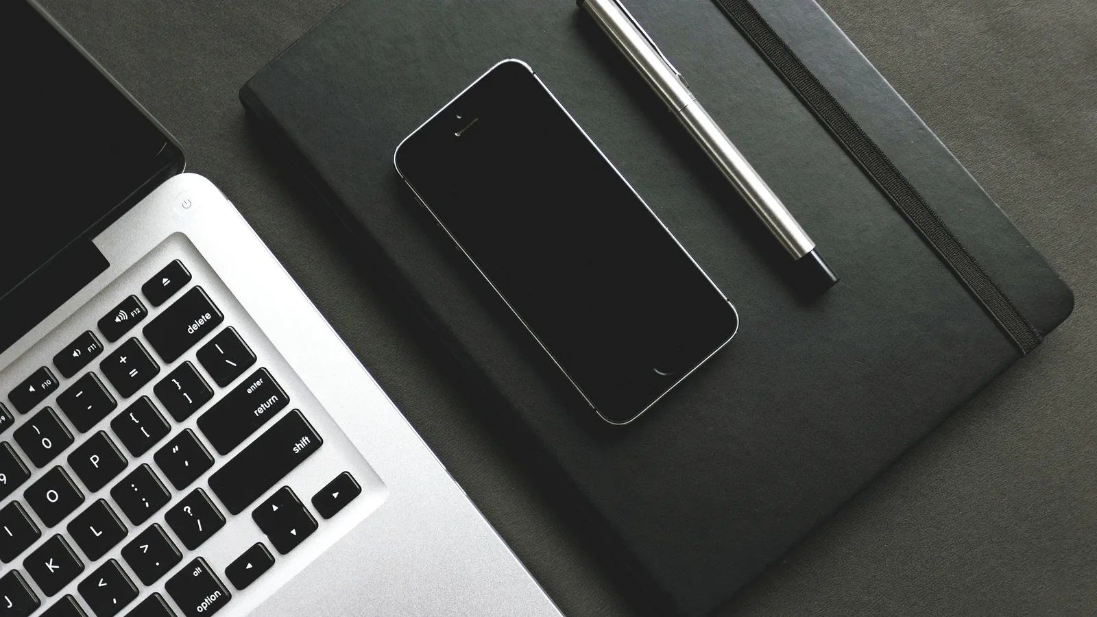 Bureau professionnel sobre avec ordinateur portable, smartphone, carnet noir et stylo